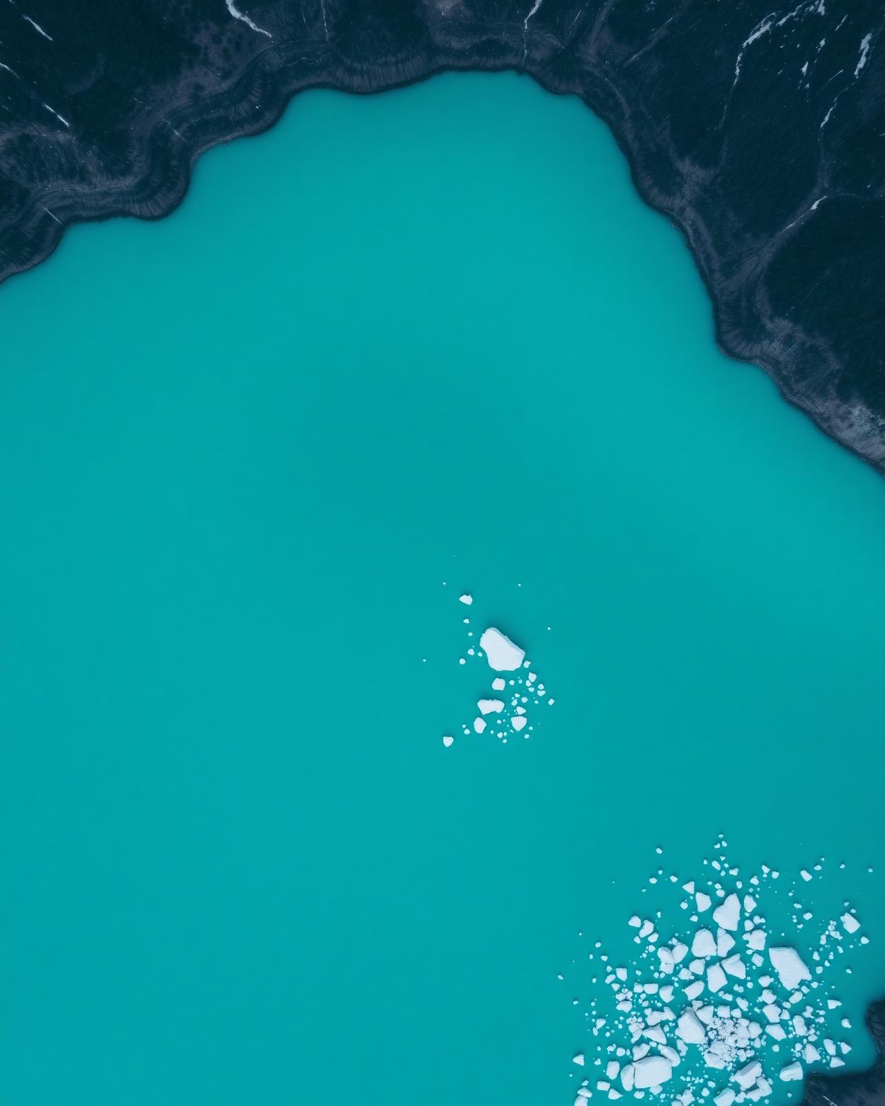 Aerial of turquoise glacial lake with ice floes
